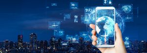 someone holding smart phone with city lights in background 303 Networks