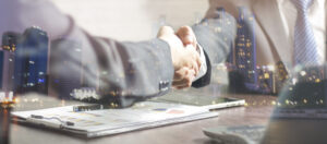 image of two partners shaking hands over a graph and iPad 303 Networks